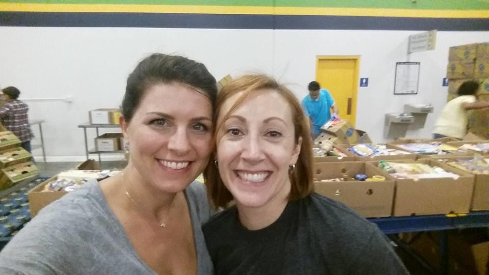 Lauren Fernandez 05JD/MBA, left, and fellow alum Valerie Henderson 06MBA share a smile as they volunteer at the Atlanta Community Food Bank.