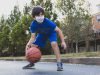 A kid plays basketball at summer camp