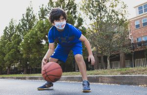 A kid plays basketball at summer camp