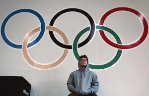 Matthew Jones sits in front of olympic rings