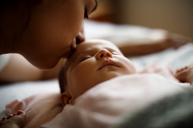 A mother kisses her baby