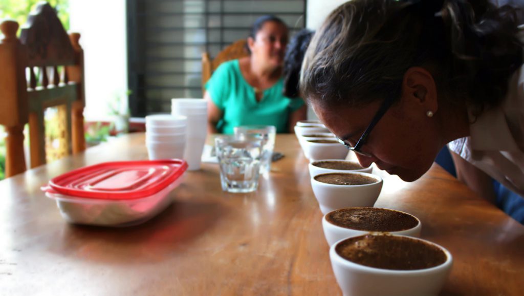 A woman smells fresh coffee.