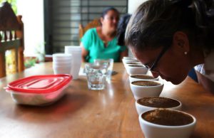 A woman smells fresh coffee.