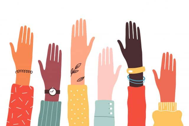 Hands of diverse group of people together raised up. Concept of support and cooperation, girl power, social community.