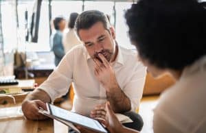 Business executives looking at paper andtalking.