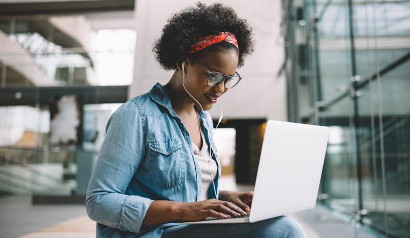 Photo: Young African American woman with open laptop