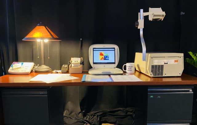 Photo: Lamp, laptop, and overhead projector on a desk top 