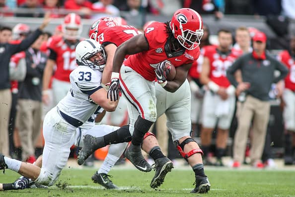 Photo: football player running and tackling on field