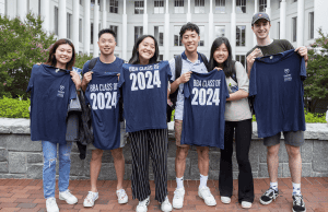 Goizueta BBA students from the class of 2024 pose with t-shirts at a social event.