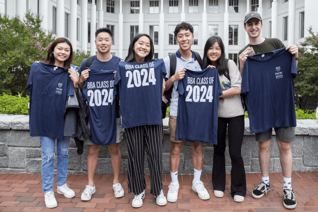 Goizueta BBA students from the class of 2024 pose with t-shirts at a social event.