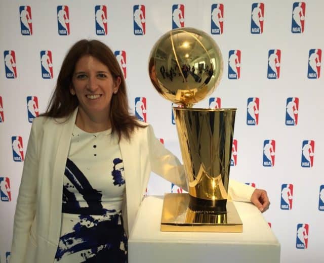 Goizueta BBA Grad Lauren Cohen posing with the NBA’s Larry O'Brien Championship Trophy