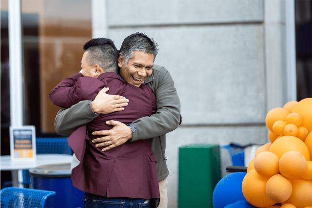 Two Goizueta alumni greeting each other with a hug at Homecoming 2023