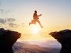 Challenge of business concept. A businessman jumping over a valley.