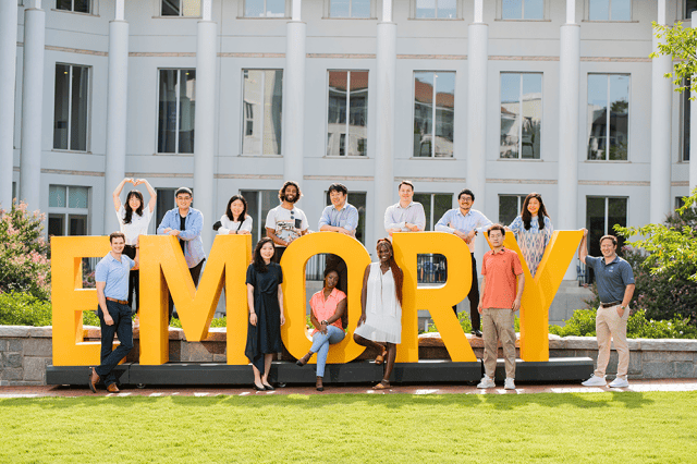 Students posing in and around the oversize Emory Letters on the lawn