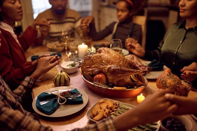 Family gathered around table at Thanksgiving