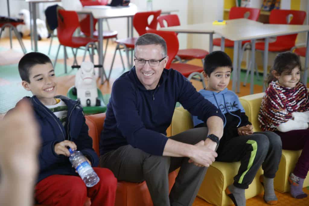 Michael Nyenhuis and a group of childrean pose during a UNICEF field visit to Kahramanmaras and Nurdagi, Turkey in March 2023. 