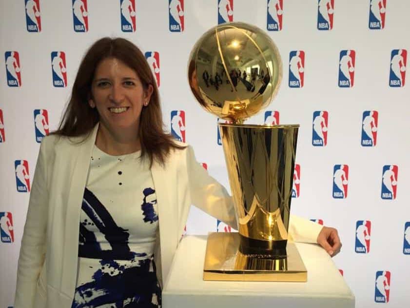 Goizueta BBA Grad Lauren Cohen posing with the NBA’s Larry O'Brien Championship Trophy