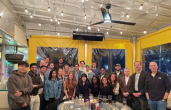 Leadership Development Fellows with faculty and executive coaches at a pizza gathering.