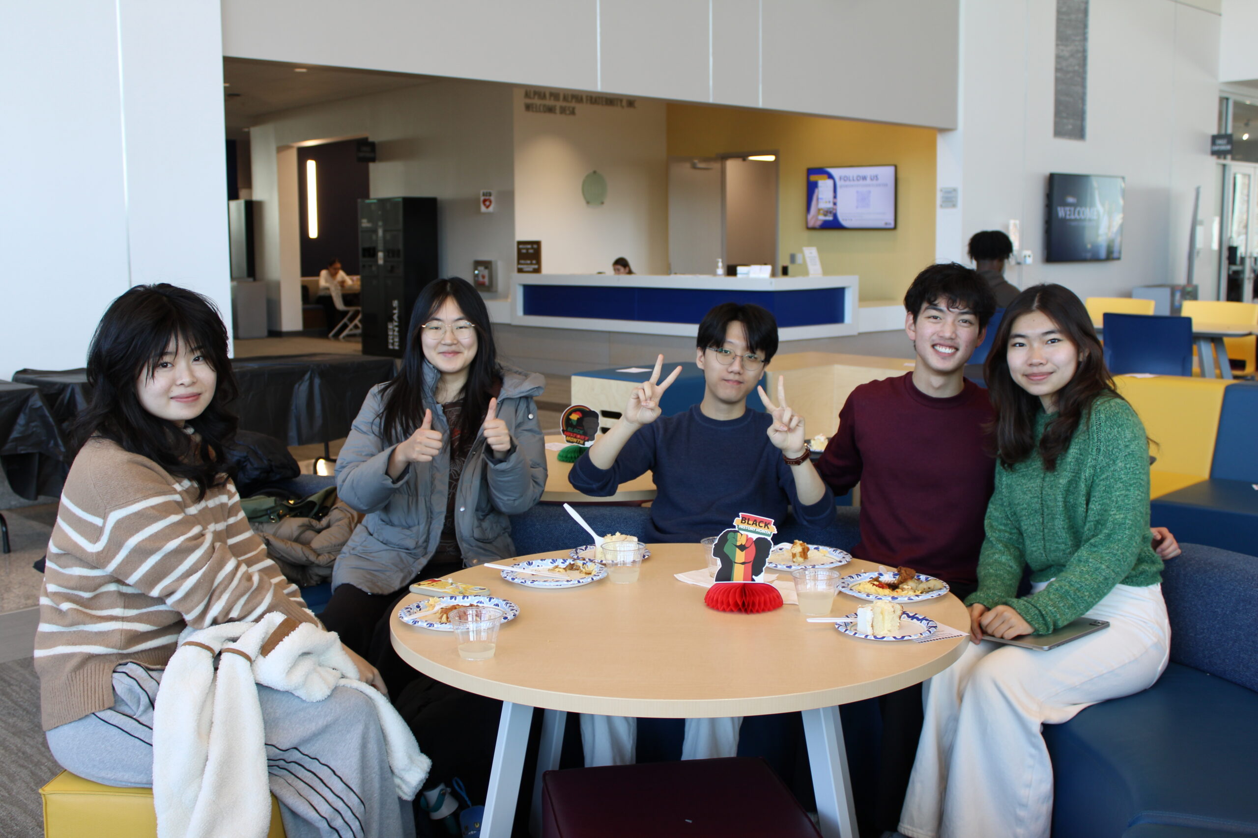 Students gathered around a table socializing during a Black History month event.