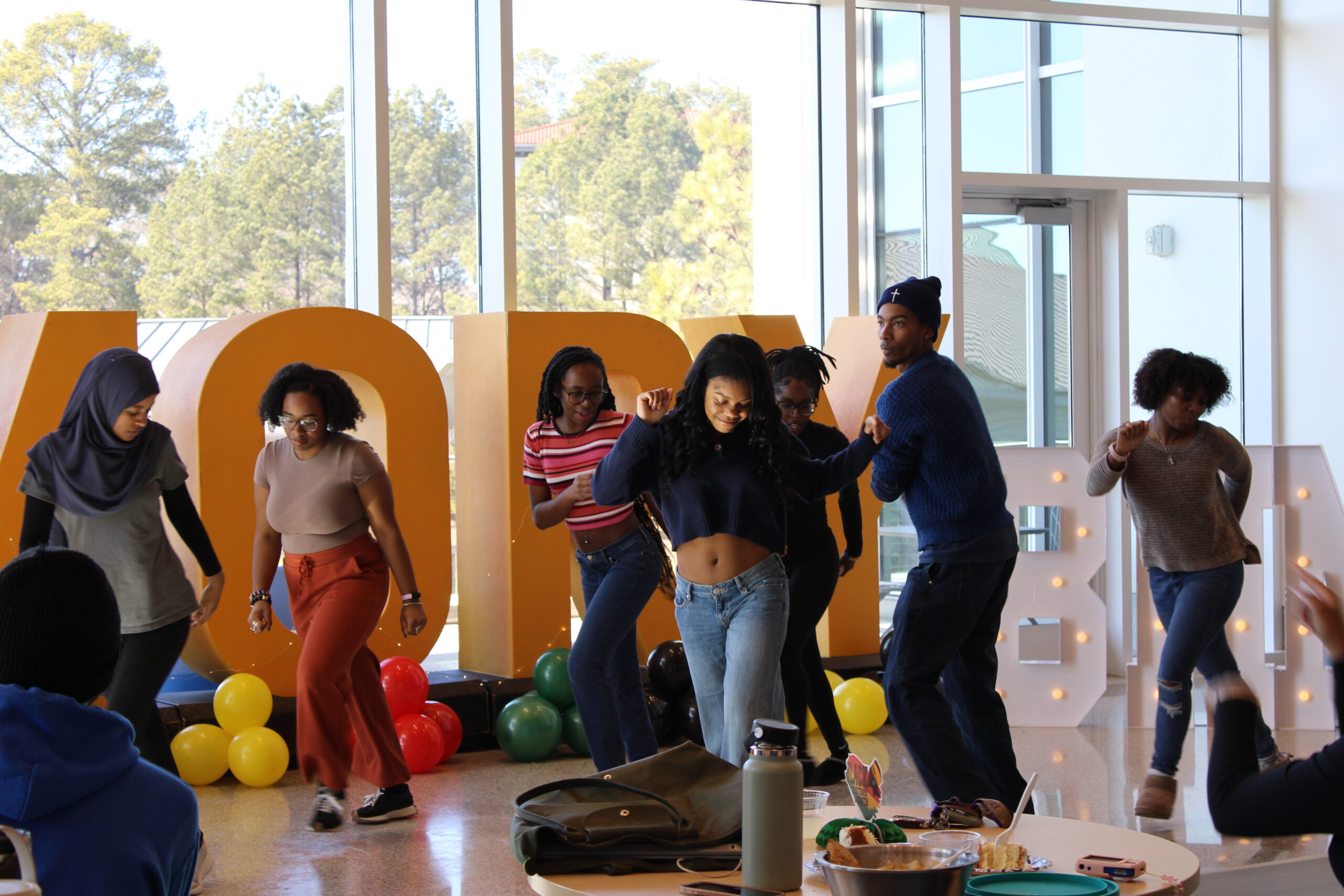 Students dance in front of the Emory letters at a Black History Month celebration.