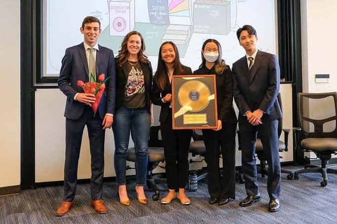 Caren Kelleher 05BBA, Founder and CEO of Gold Rush Vinyl, poses with BBA students from the winning team of an experiential learning competition at Goizueta in 2023.