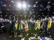 Goizueta Business School graduates celebrate by tossing their caps in the air during the Class of 2026 commencement ceremony at Gas South Arena.