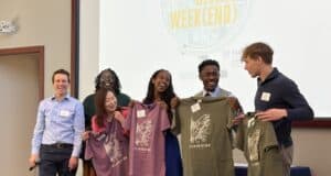 Clarkston Giving Week(end): Students Driving Community Impact Through Action Co-instructors Brian Goebel and Tene Traylor presenting the student leadership team with Clarkston t-shirts.