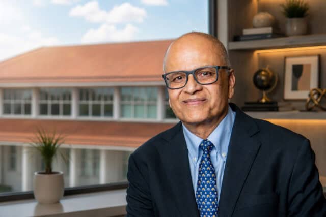 Dean Saby Mitra sits at a window at Goizueta Business School